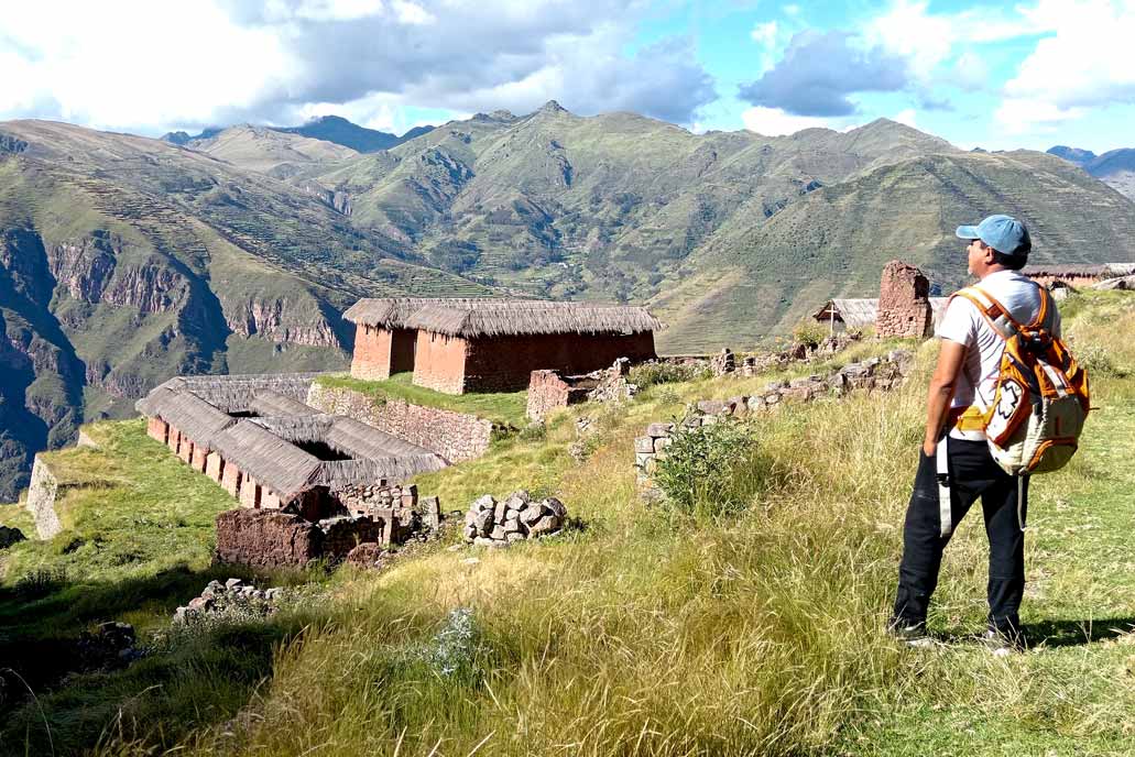 Visitante olhando para as ruínas de Huchuy Qosqo